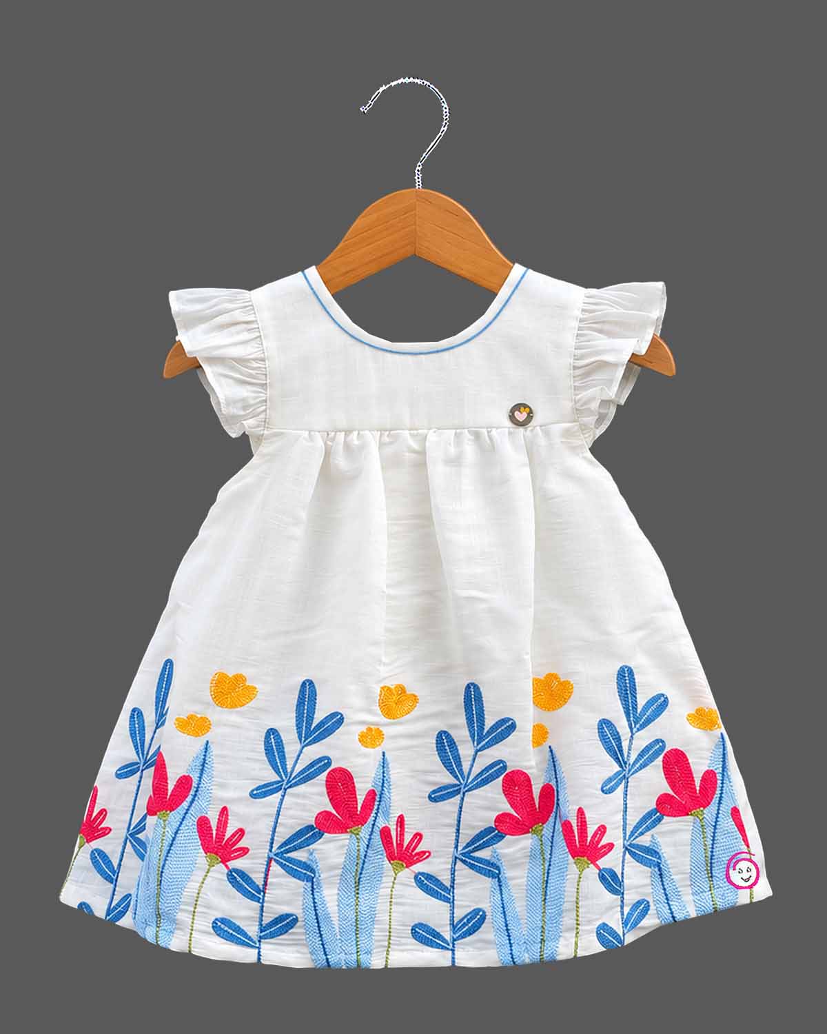 Baby girl cotton frilled frock with embroidered botanical hem and cap sleeves