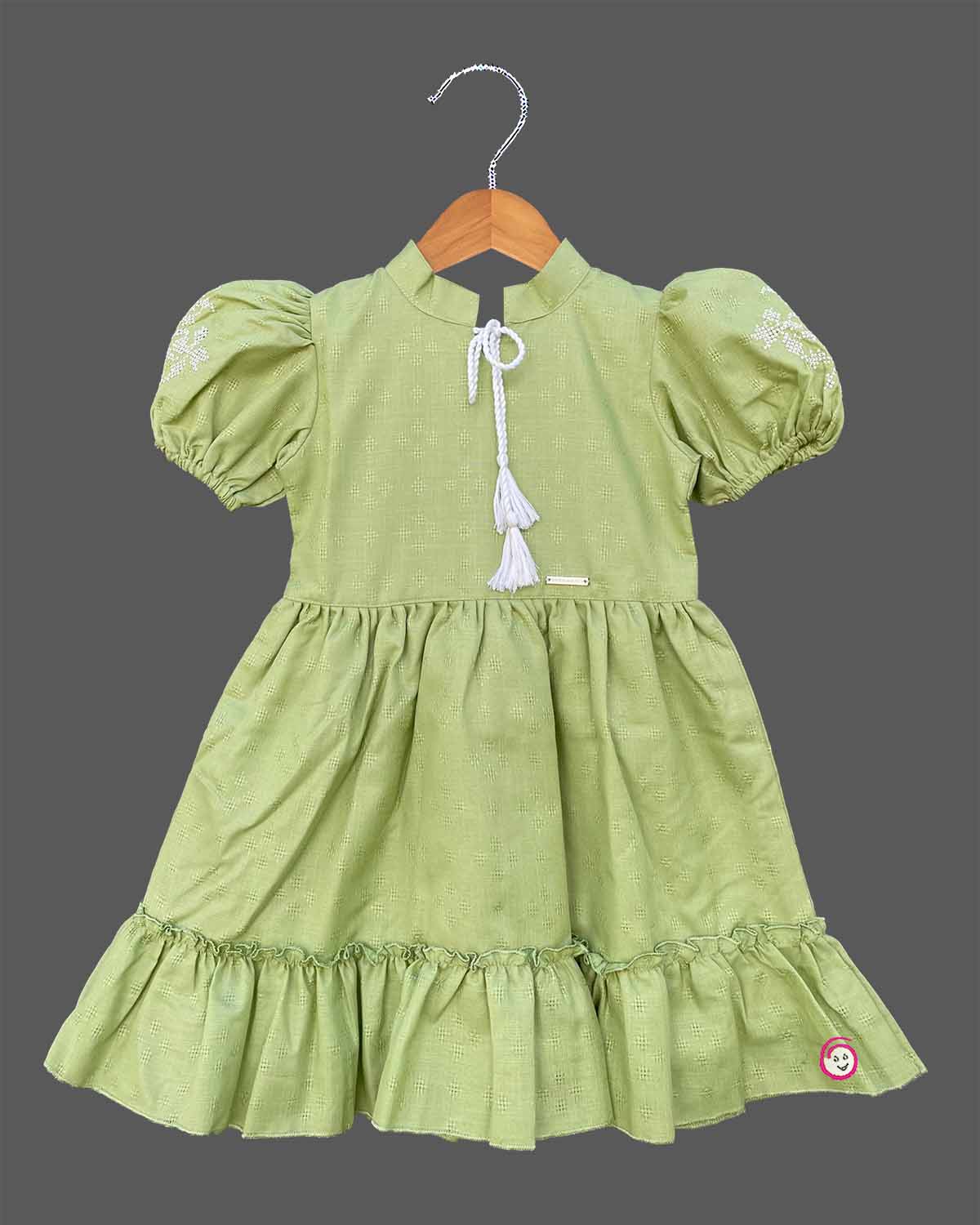 Pistachio green textured cotton girls frock with puff sleeve and tassels