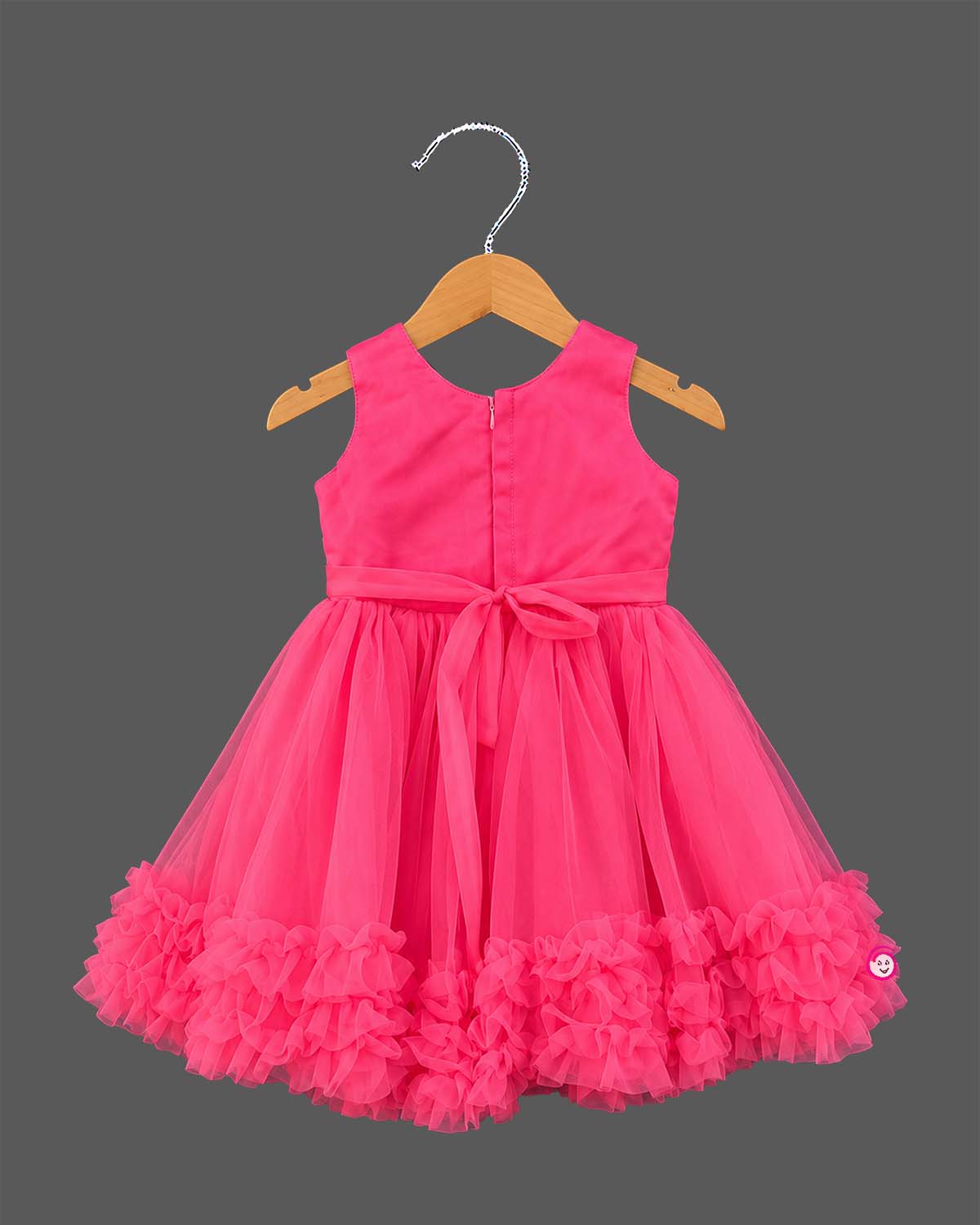 Sleeveless pleated tulle frock for girls with flower applique and ruffled hemline on hanger