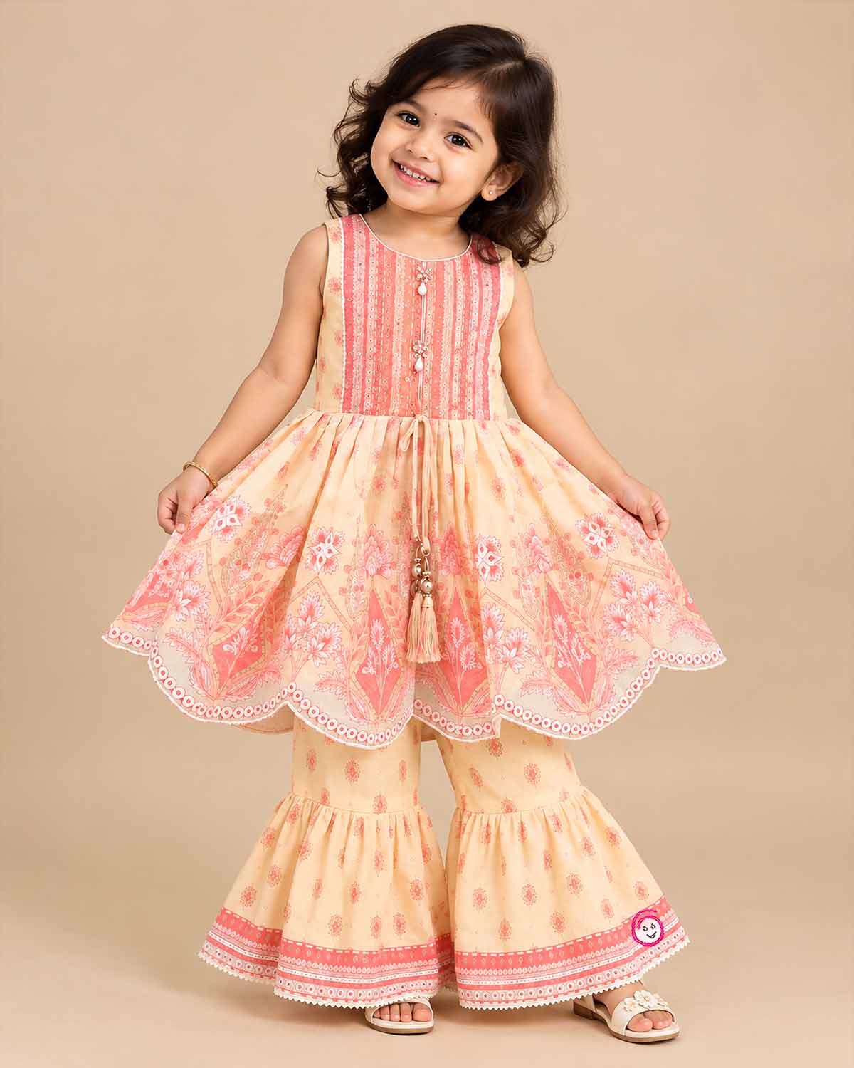 Girls printed short kurta with scalloped hem and matching tiered flared sharara pants for ethnic wear.