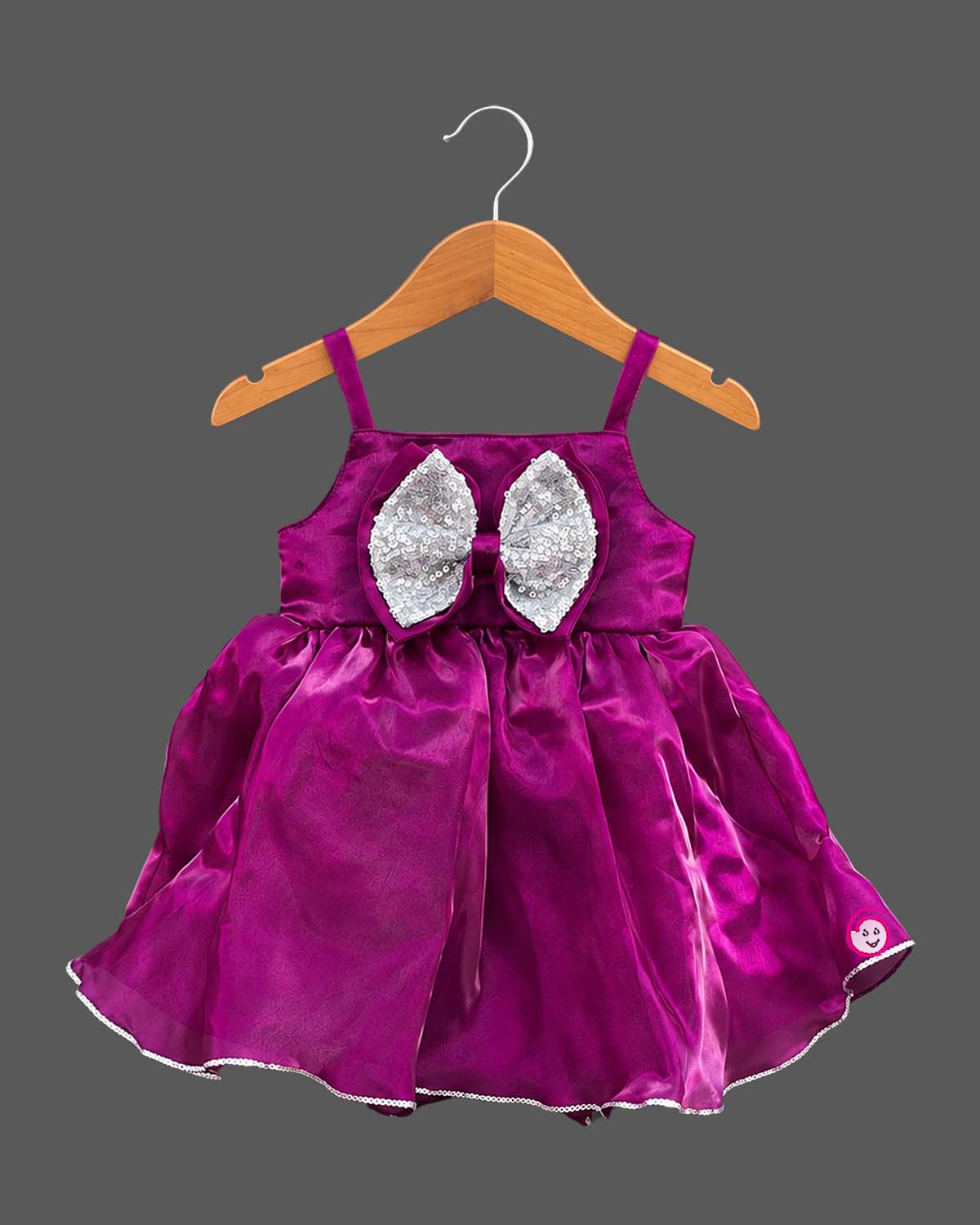 Toddler satin party frock featuring a sequined double bow and sleeveless strap design