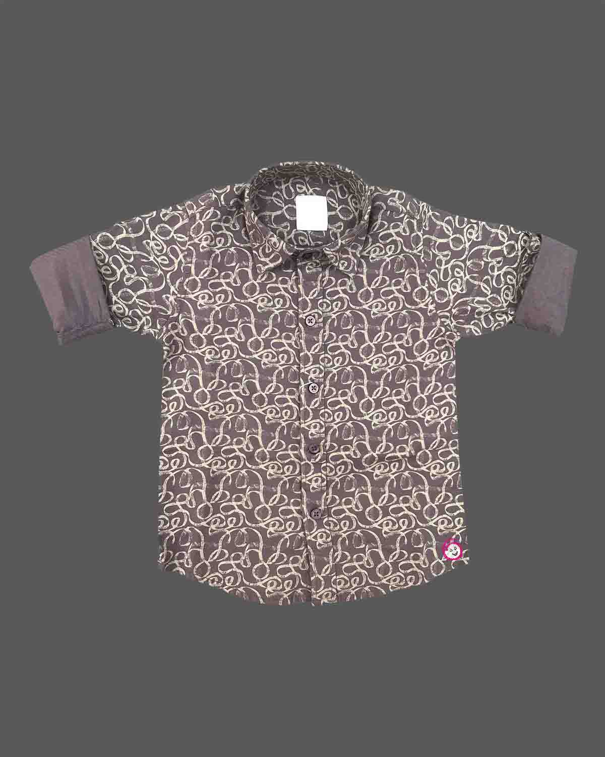 Front view of a printed collared shirt for boys with rolled-up cuffs and button closures on a neutral background.