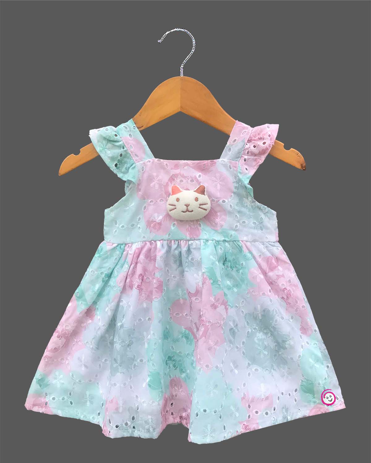 Sleeveless cotton Schiffli eyelet frock with delicate floral print and cat face motif on front bodice.