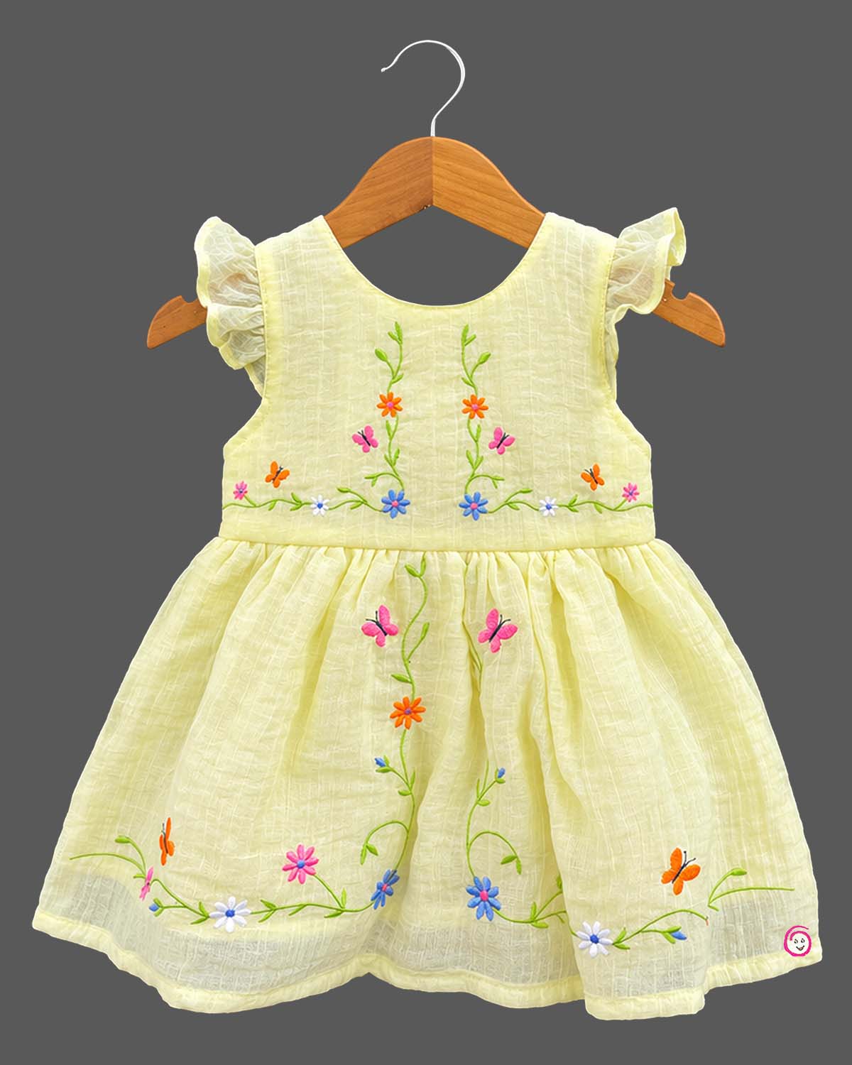 Frill sleeve organic casual frock with embroidered floral vines and baby casual wear dress styling details.