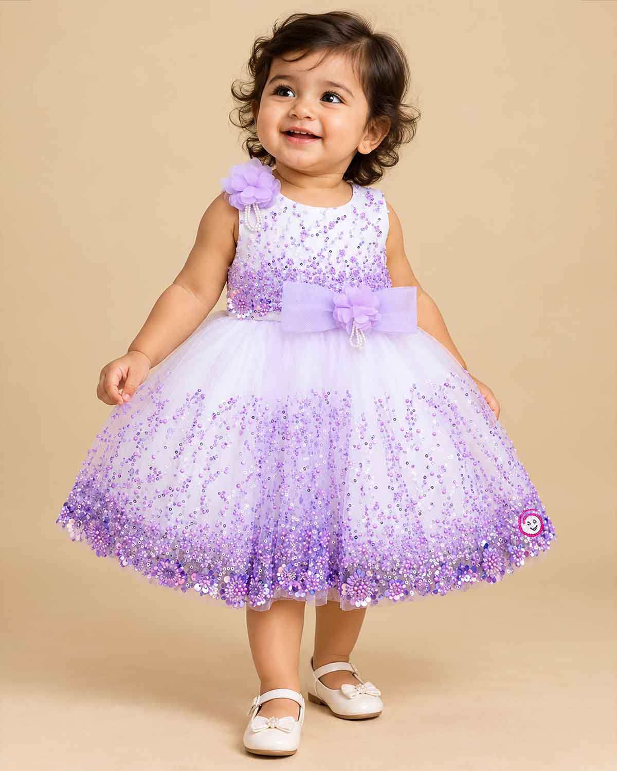 Girls sleeveless sequin embellished tulle flared frock with waist bow appliqué and round neck.