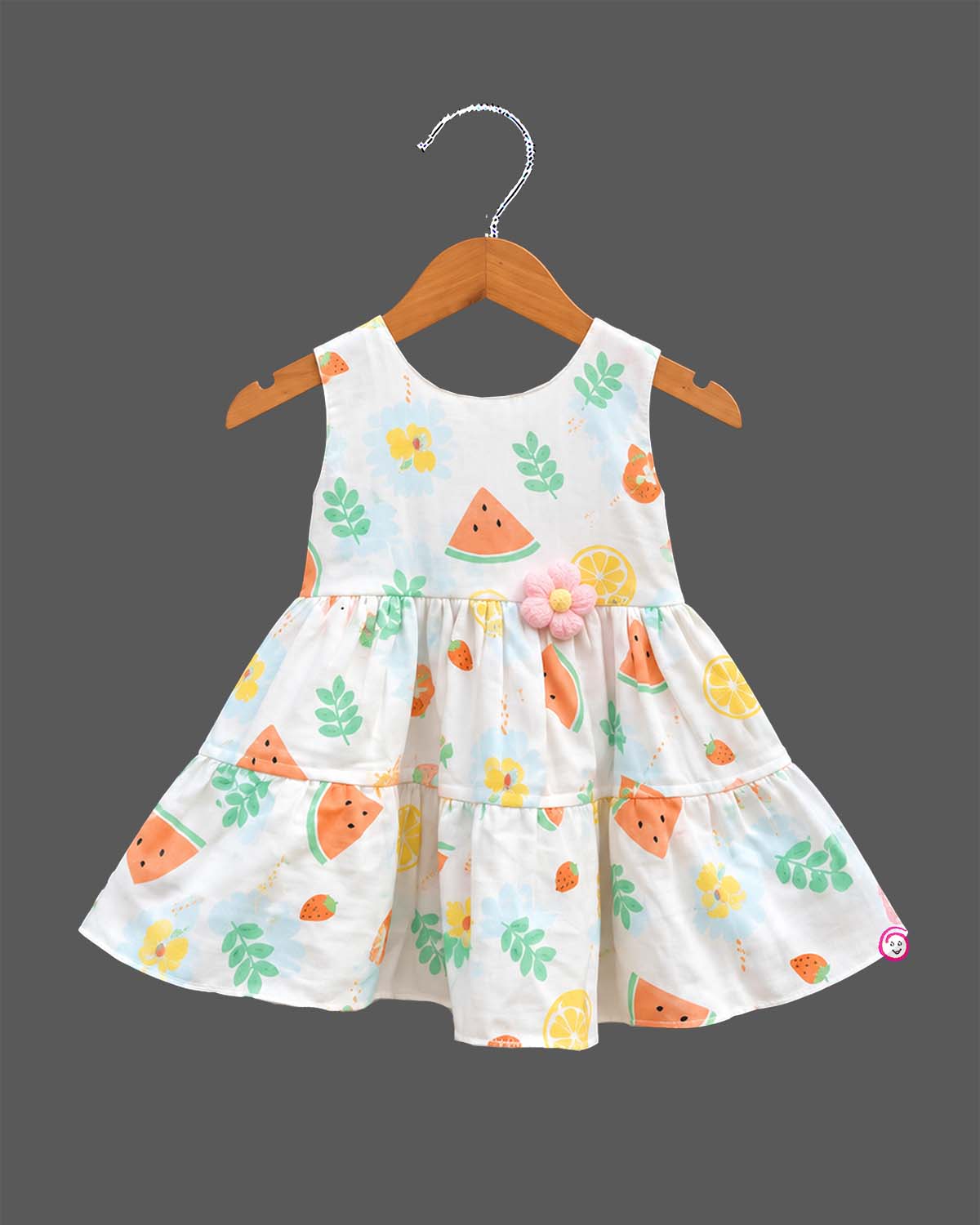 Sleeveless fruit print tiered cotton frock for girls featuring floral waist appliqué and flared A-line silhouette.