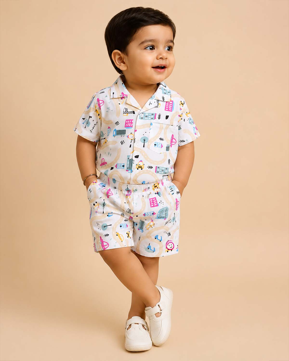 Boys 2-piece cotton casual co-ord set featuring a short-sleeve collared printed shirt and matching shorts in white with colorful cars, roads, and buildings print