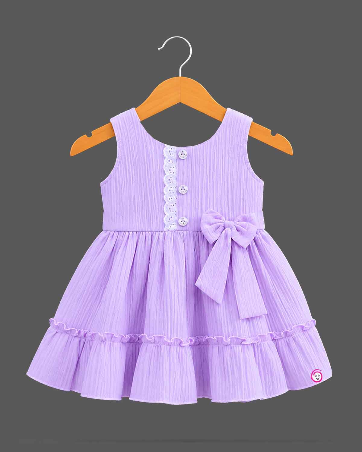Pleated tiered frocks for baby girl featuring a side bow, lace-trimmed button placket, and round neck