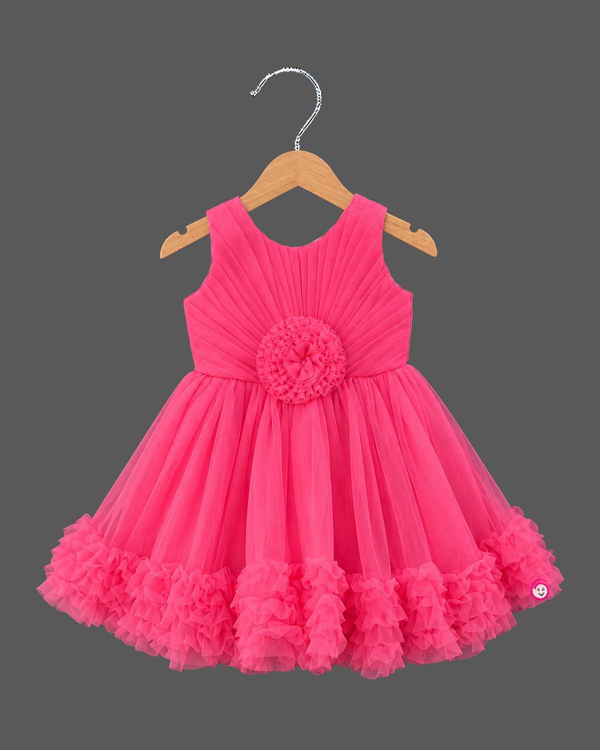 Sleeveless pleated tulle frock for girls with flower applique and ruffled hemline on hanger