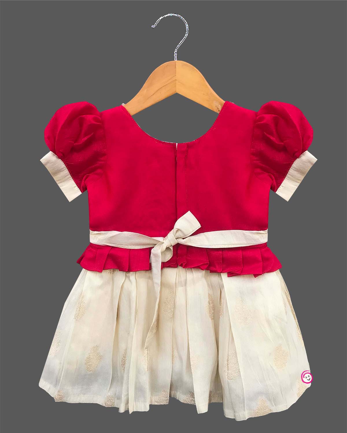 Detailed view of a kid's festive outfit with puff sleeves, intricate neck embroidery, and a pleated floral brocade skirt.