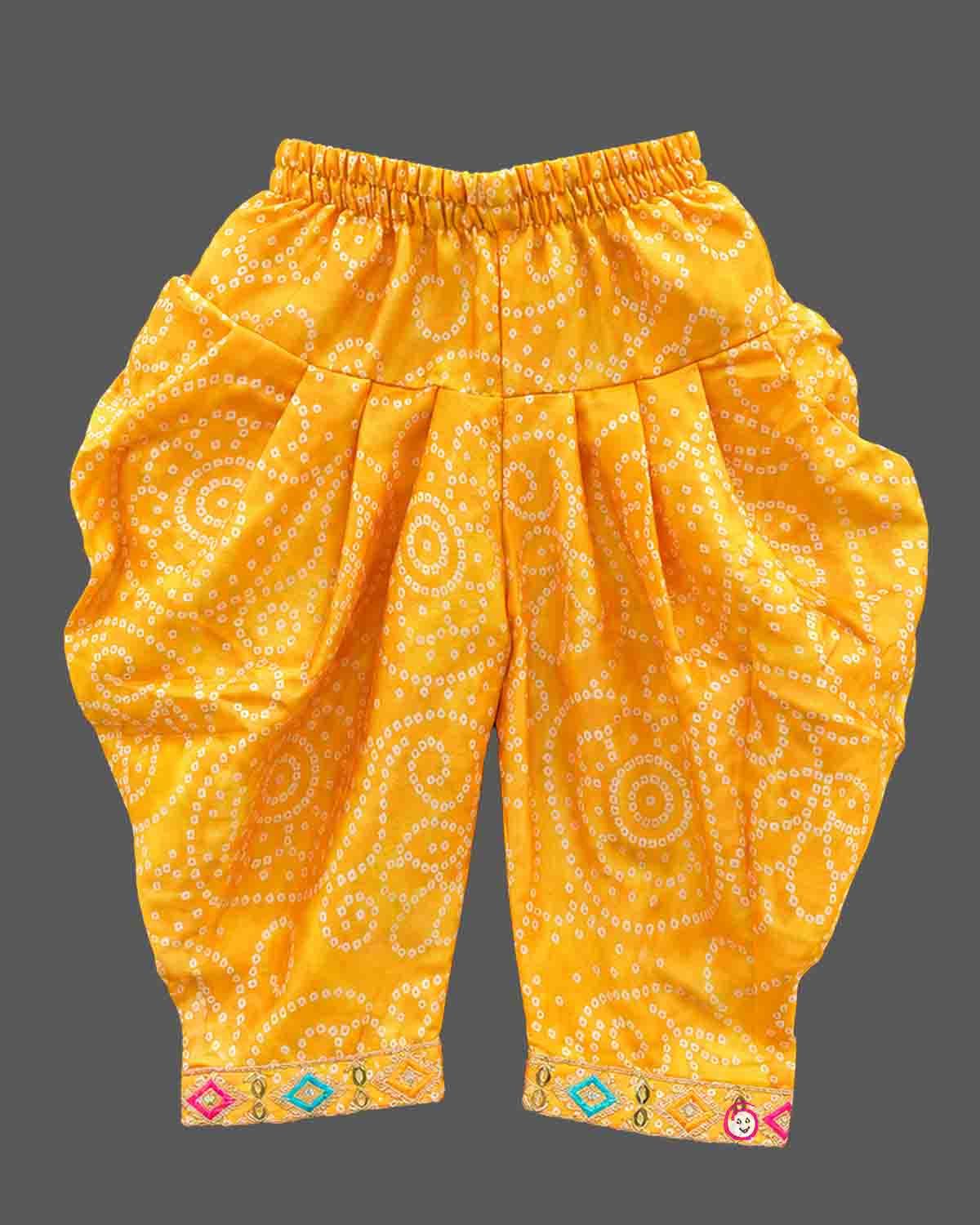 Sleeveless bandhani print short kurti with mirror work yoke paired with pattu langa for kids dhoti pants.