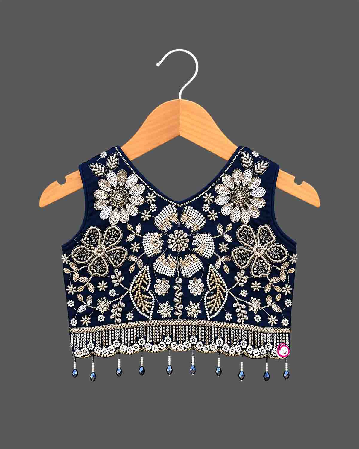 Girls sleeveless embroidered choli lehenga set with beaded fringe hem, tassel drawstring, and pleated flared skirt.
