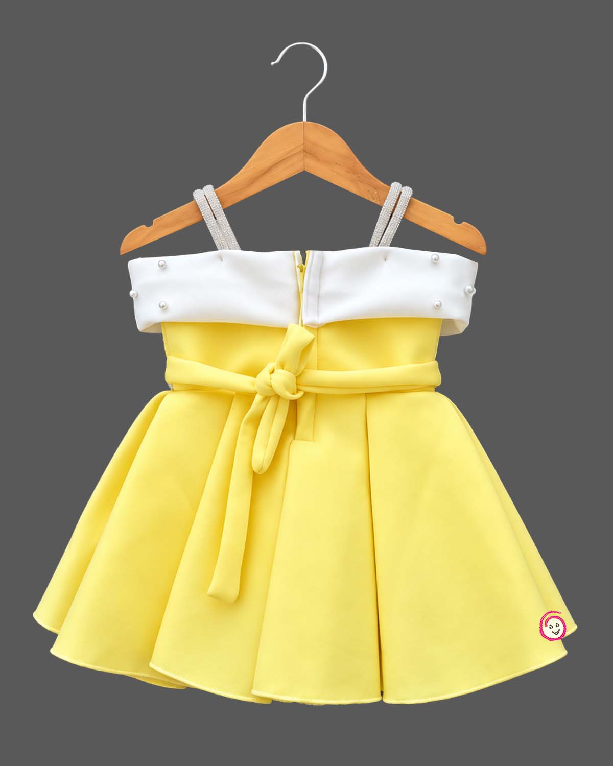 Scuba frock for baby girl featuring structured box pleats and pearl-embellished bow bodice.