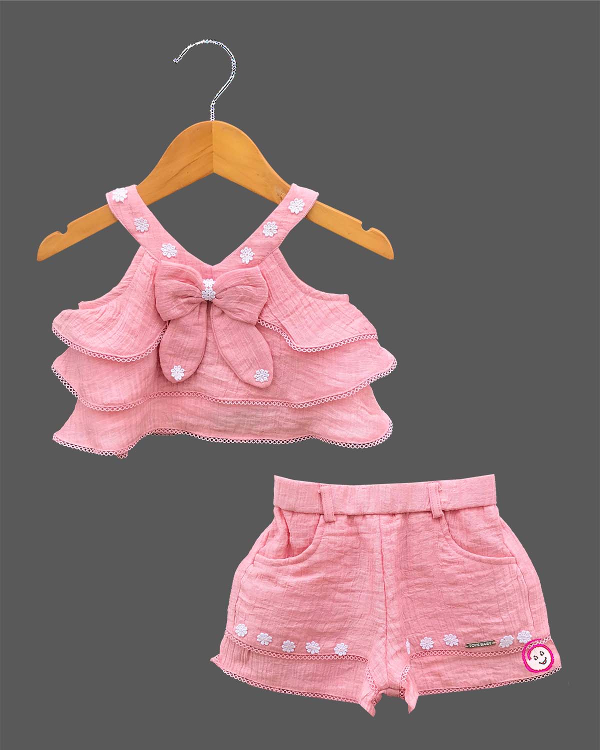 Sleeveless tiered ruffle top with bow applique and embroidered matching shorts for a toddler