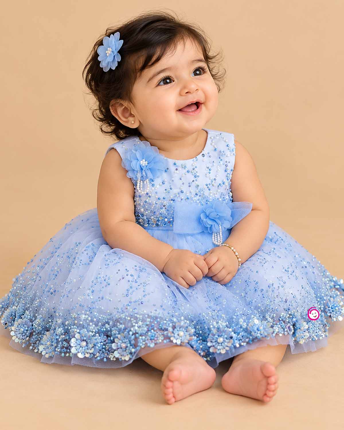 Girls embellished mesh frock with sequins, pearl brooch, floral waist appliqué, and layered net flare.
