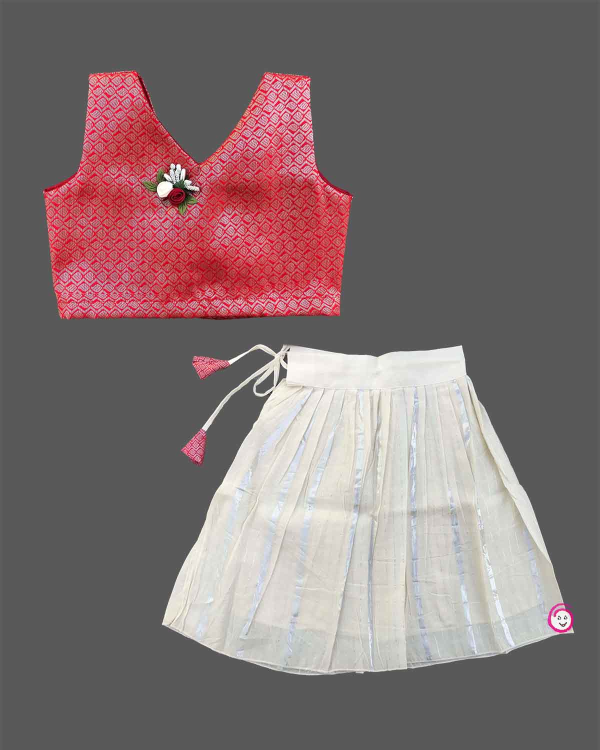 Kids festive wear featuring V neck jacquard blouse with floral brooch detail and zari pleated skirt set