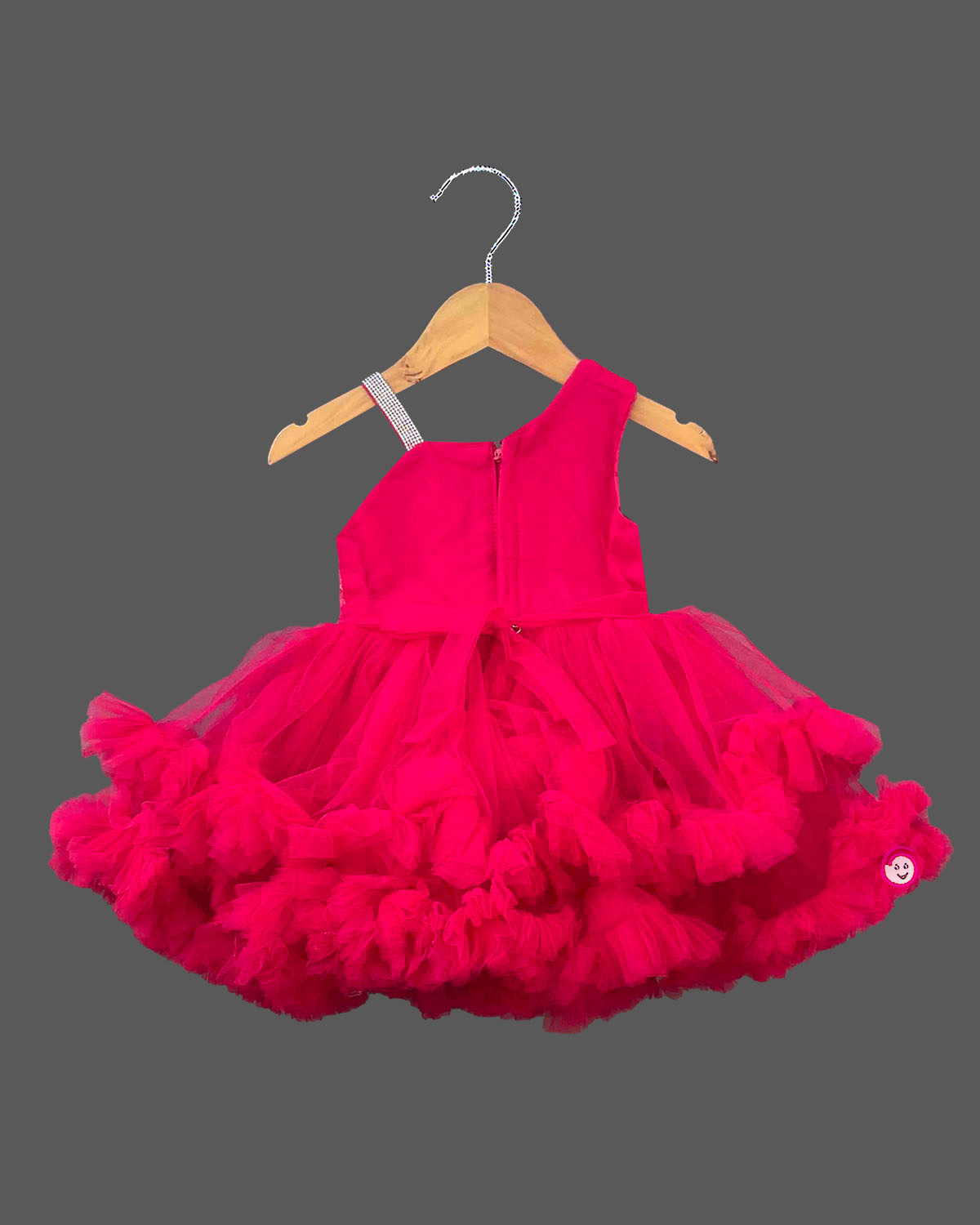 Sequined high-low baby party wear dress with layered tulle ruffle skirt and embellished strap.