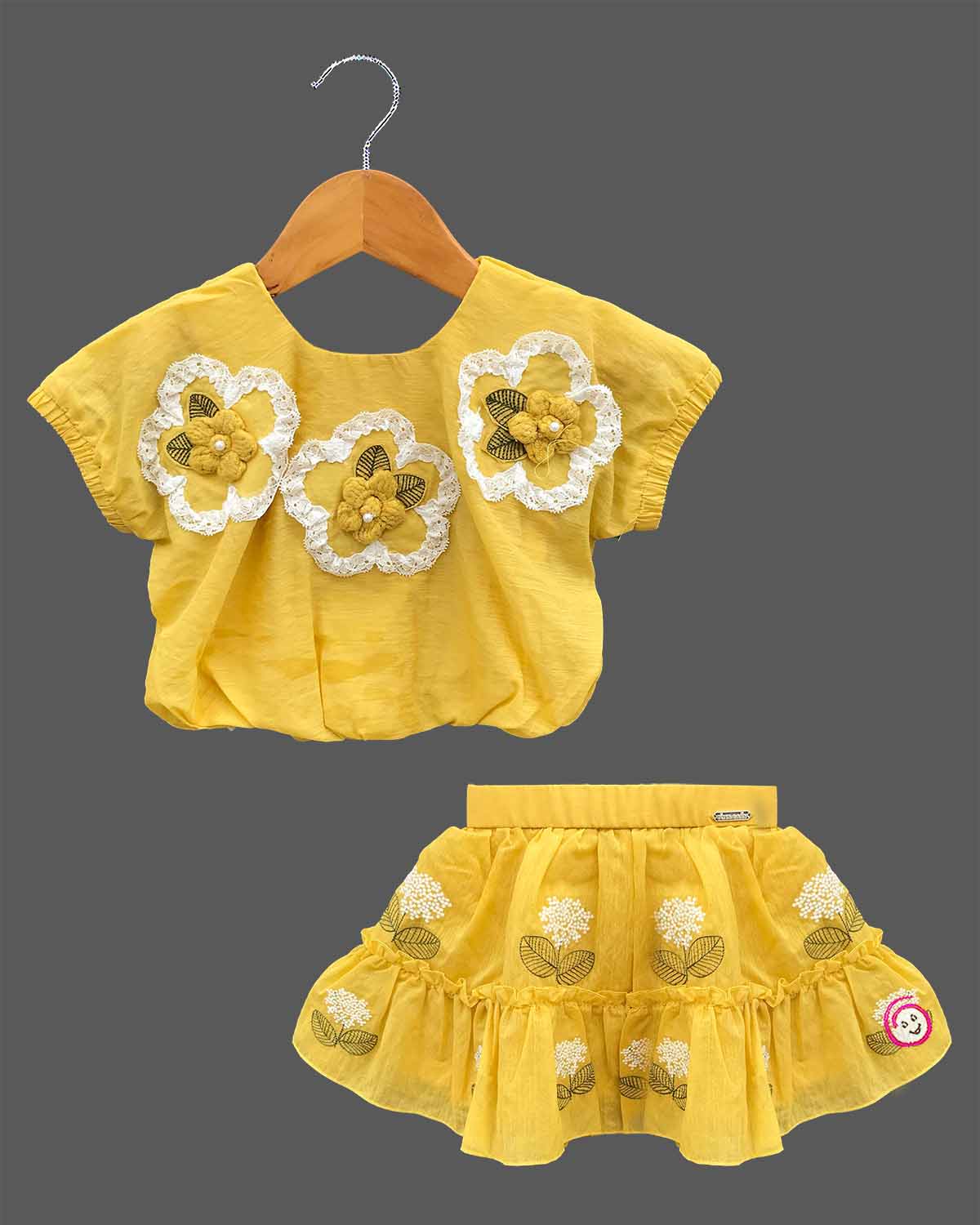 Cap sleeve top with lace flower motifs paired with a tiered embroidered skirt for a young fashionista