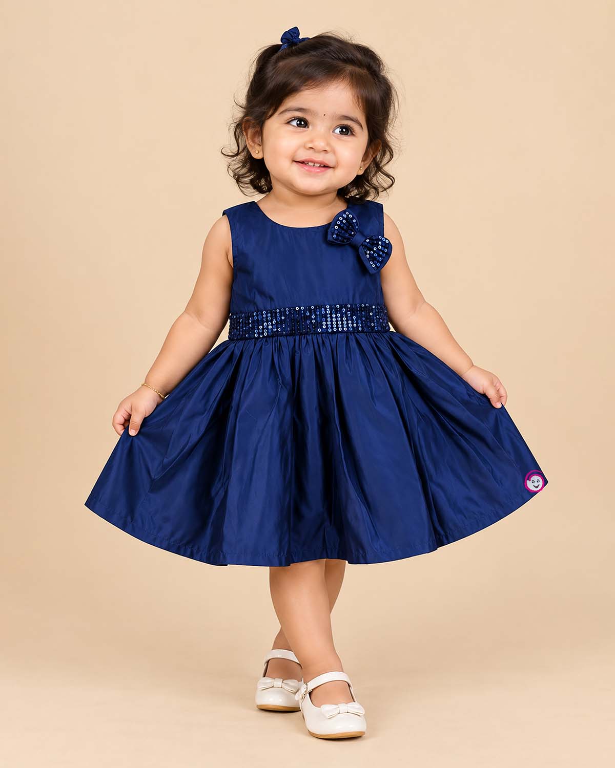 Sleeveless A-line frock with sequined waist belt and shoulder bow, styled as a baby casual wear dress.