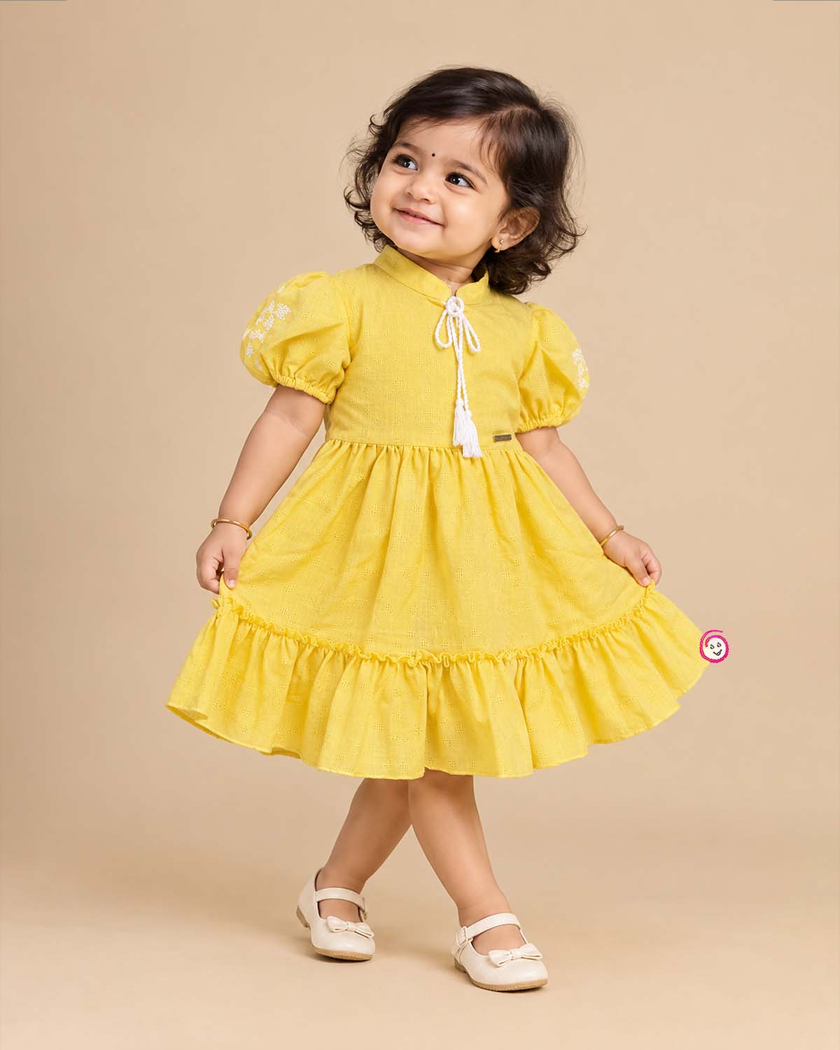 Infant yellow cotton frock with puff sleeves and tassels for family picnic