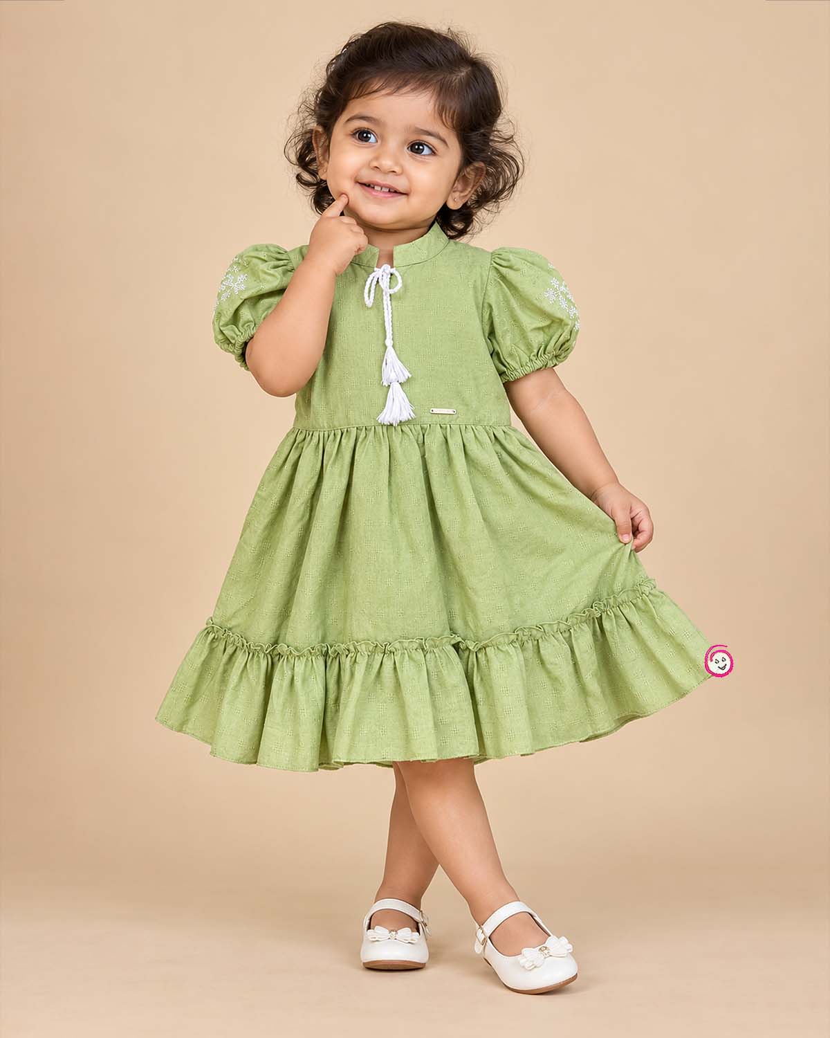 Pistachio green textured cotton girls frock with puff sleeve and tassels