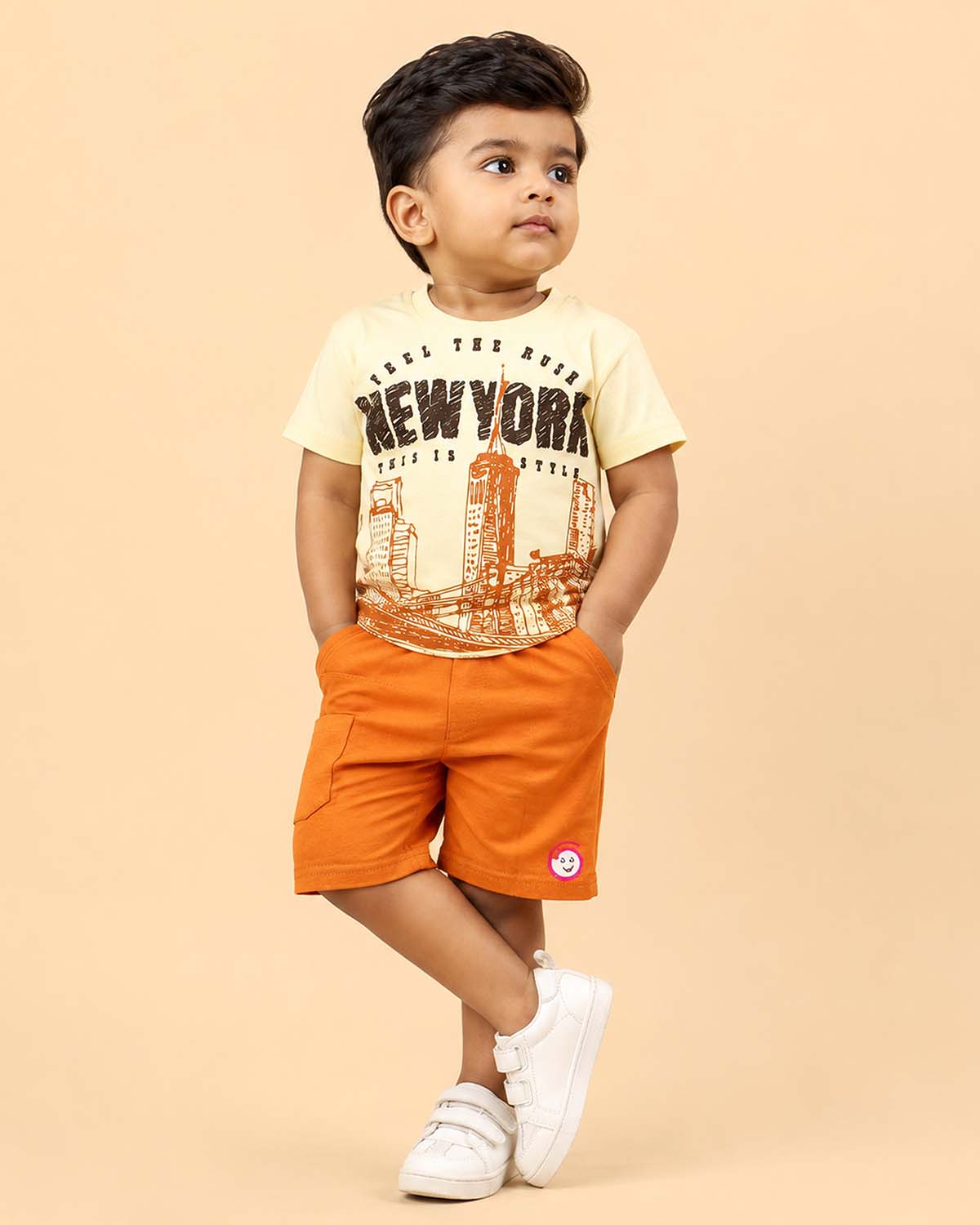 Light yellow graphic t-shirt with New York cityscape print and rust orange elasticated shorts baby boy top and shorts set for summer vacations, playdates, and park outings