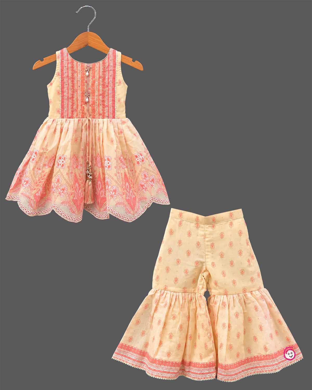 Girls printed short kurta with scalloped hem and matching tiered flared sharara pants for ethnic wear.