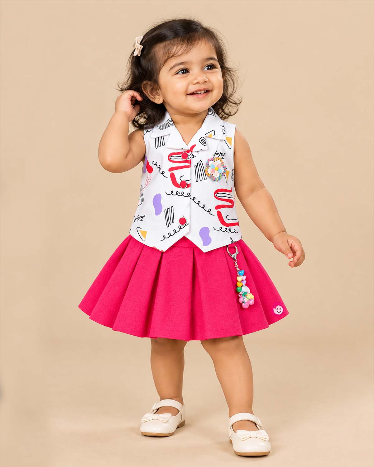 Girls sleeveless printed collar waistcoat with brooch and pleated flared skirt for kids party wear.