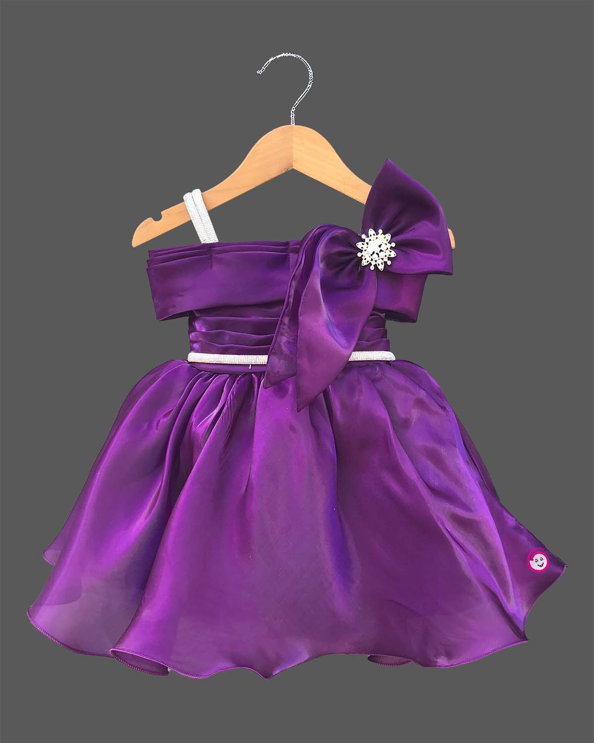 Deep purple satin and organza party frock for baby girl featuring oversized side bow, rhinestone shoulder straps, and crystal brooch for first birthday outfit for girl and wedding celebrations