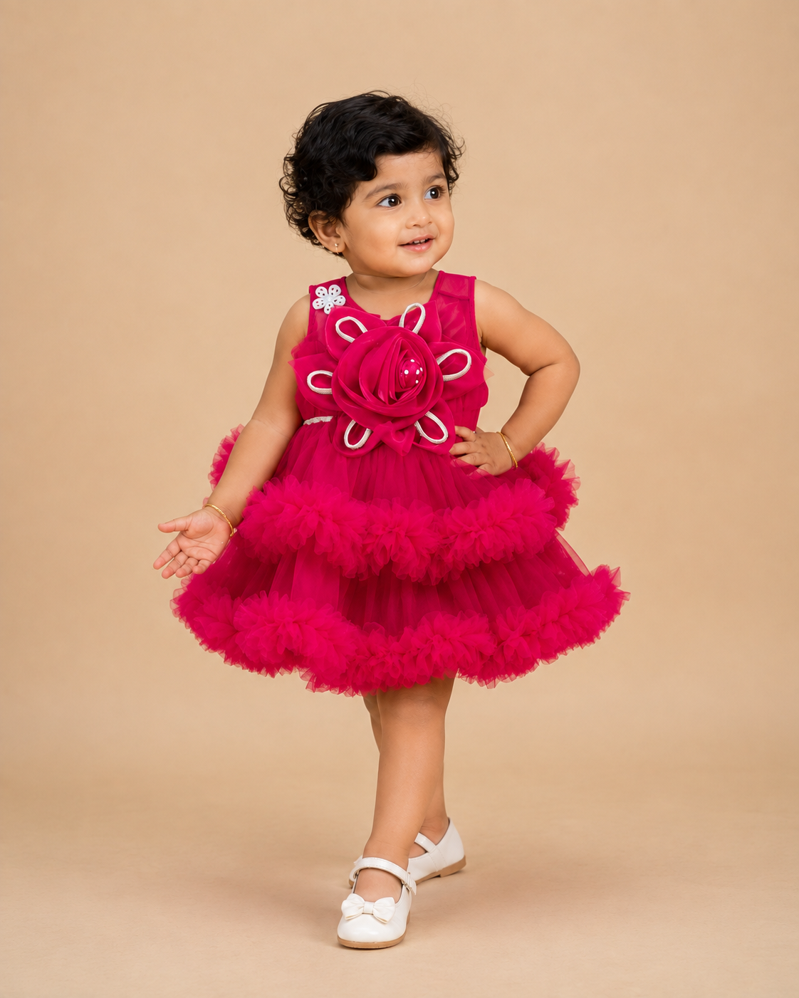 Voluminous party frock for little princess featuring a large statement rosette bodice and heavily ruffled tiered net skirt displayed on a hanger.
