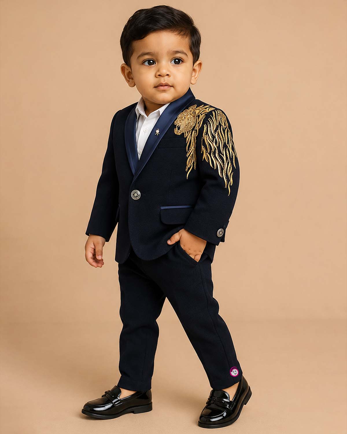 Boys blue designer tuxedo suit set featuring a shawl collar blazer with intricate gold shoulder embroidery, shirt, waistcoat, bow, and matching blue formal pant