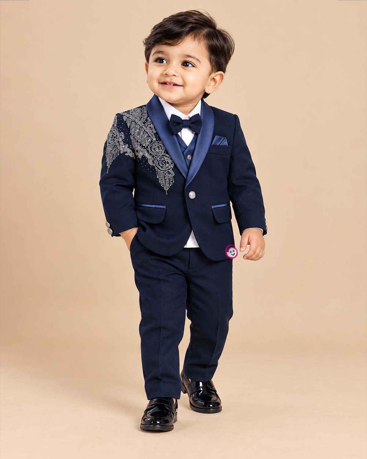 Blue boys formal suit with silver shoulder embroidery, white shirt, and bowtie
