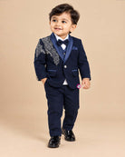 Blue boys formal suit with silver shoulder embroidery, white shirt, and bowtie
