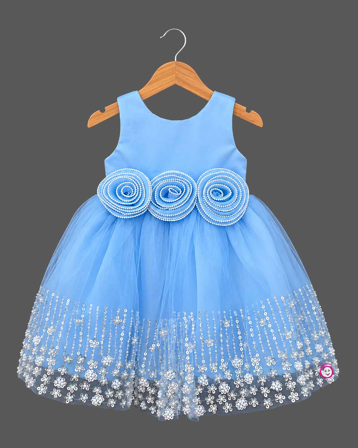 Sleeveless tulle net baby party wear dress with pearl rosette waist and sequined floral hemline.