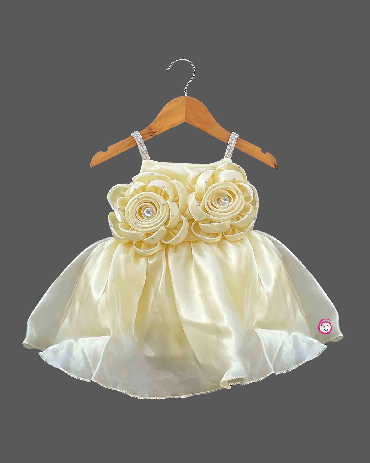 Baby party wear dress featuring satin rosette appliqués, embellished shoulder straps, and a flared organza skirt.