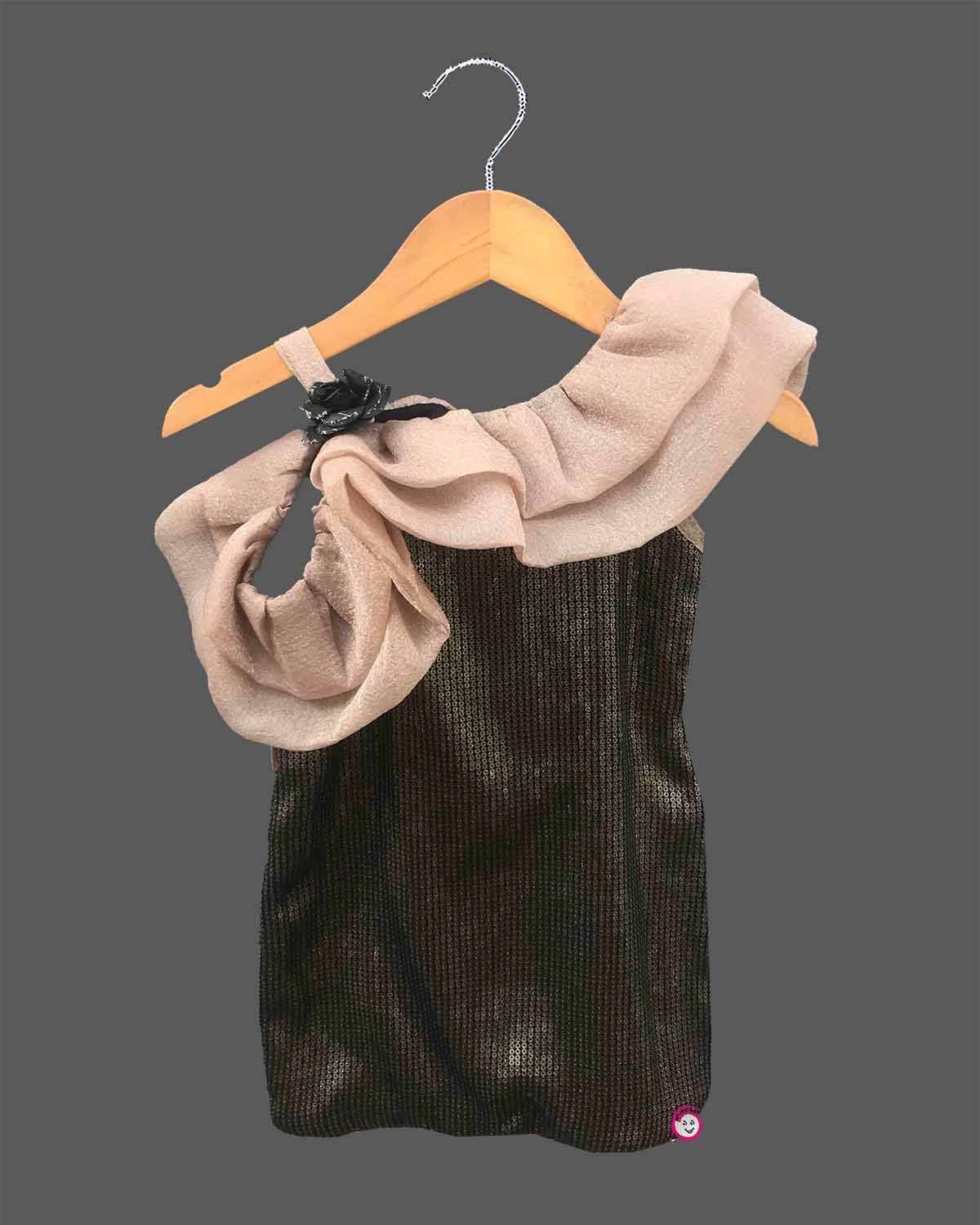 One shoulder girls toddler sequin party dress with light brown shoulder ruffle, black sequin body, and a black rose detail, hanging on a wooden hanger against a dark grey background, with a small OPUS RKID logo in the corner. 