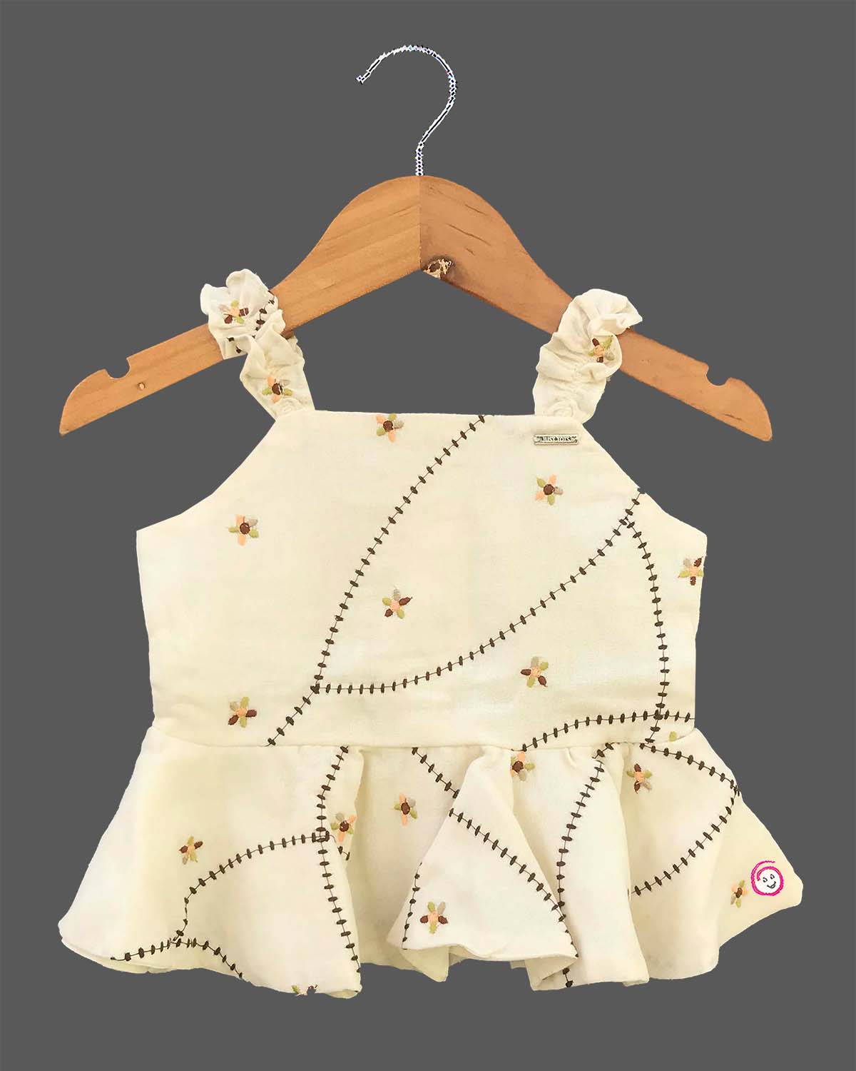 A cute patterned cotton co-ord set for baby girls featuring a sleeveless peplum top with ruffle straps and matching pants on a hanger.