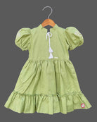 Pistachio green textured cotton girls frock with puff sleeve and tassels