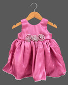 Sleeveless satin fit-and-flare dress with pearl rosette waist accents and baby party wear dress detail.