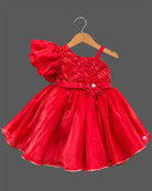 Girls sequin one shoulder frock with dramatic ruffle sleeve, floral waist applique, and flared layered skirt.