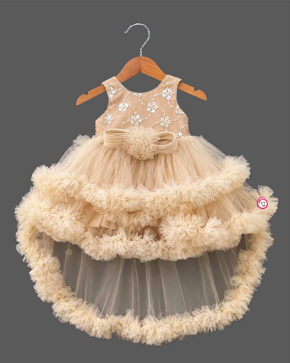 Beige cream net party frock for girls featuring sequin floral embroidery, sleeveless bodice, and tiered ruffle high-low hem design