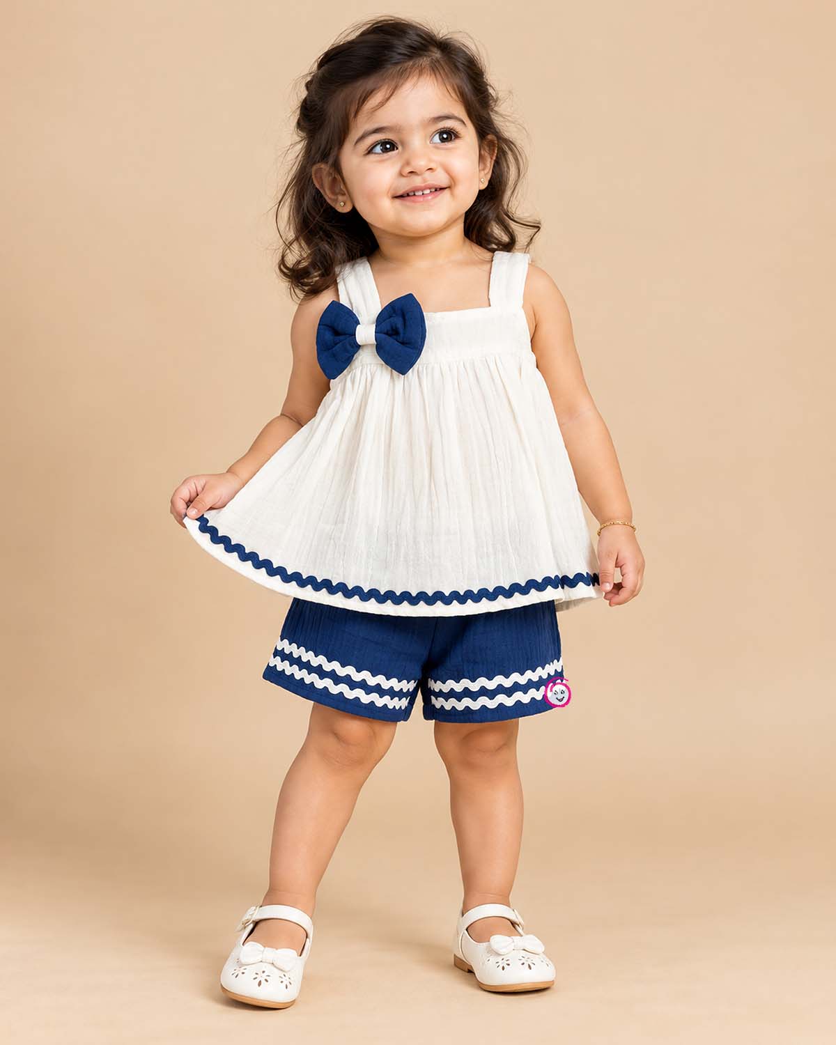Sleeveless A-line top with decorative bow paired with wave-trimmed shorts.