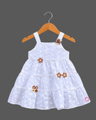 Sleeveless  tiered frock with decorative appliques and casual frock details.