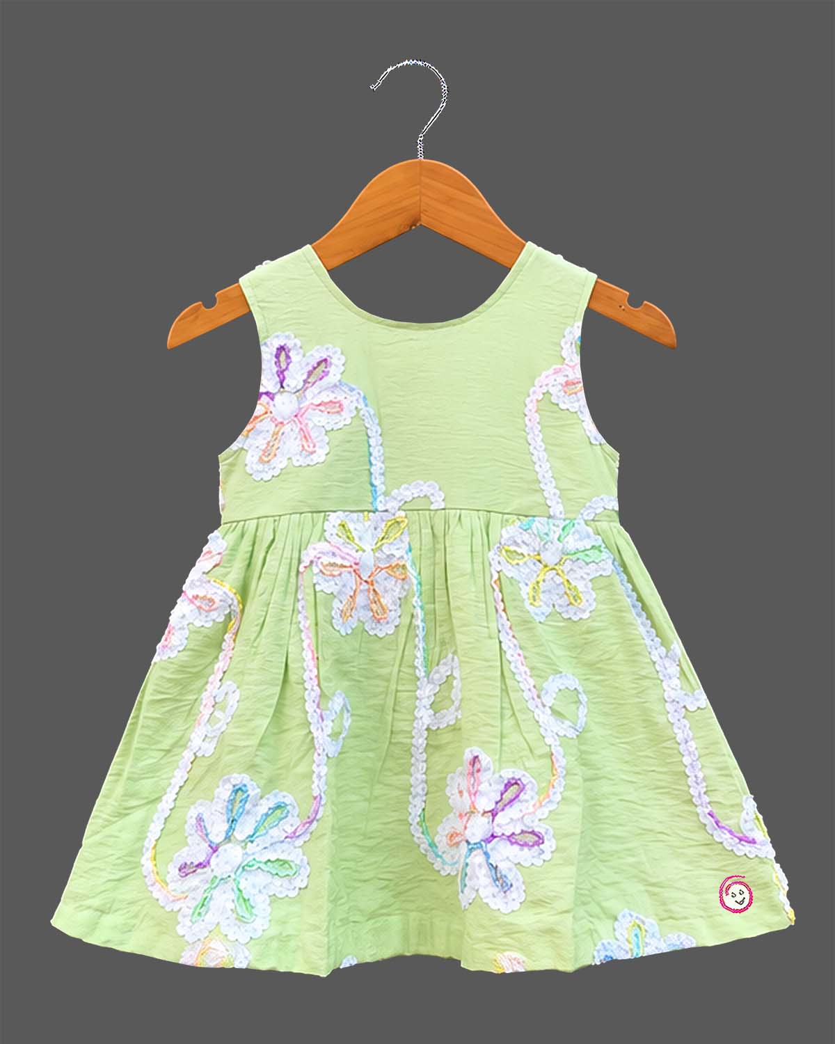 Sleeveless cotton A-line frock with floral lace appliqués and round neck for girls.