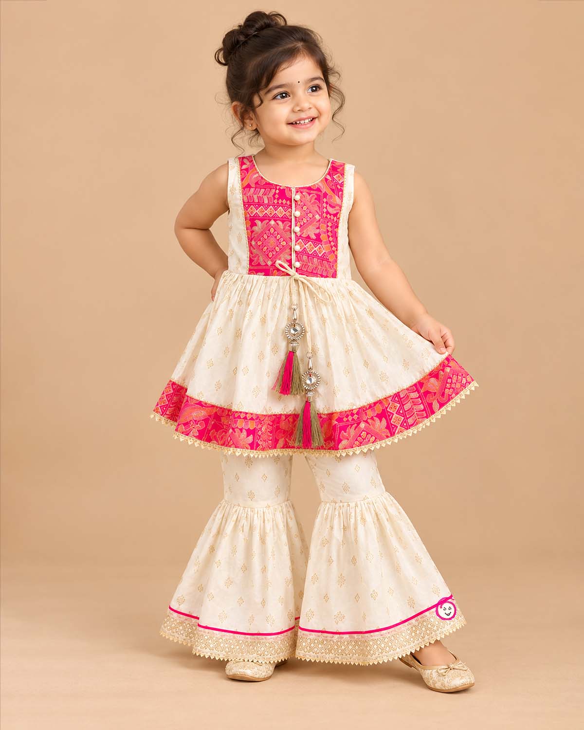 Sleeveless printed short kurta and flared tiered kids sharara set with gota trim details.