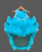 Glittering embellished flower applique party frock for little princess with ruffled high-low net skirt displayed on a wooden hanger.