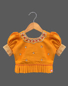 Three-piece ethnic traditional outfit for girls comprising an embroidered top with puff sleeves, a pleated zari skirt, and a light dupatta.