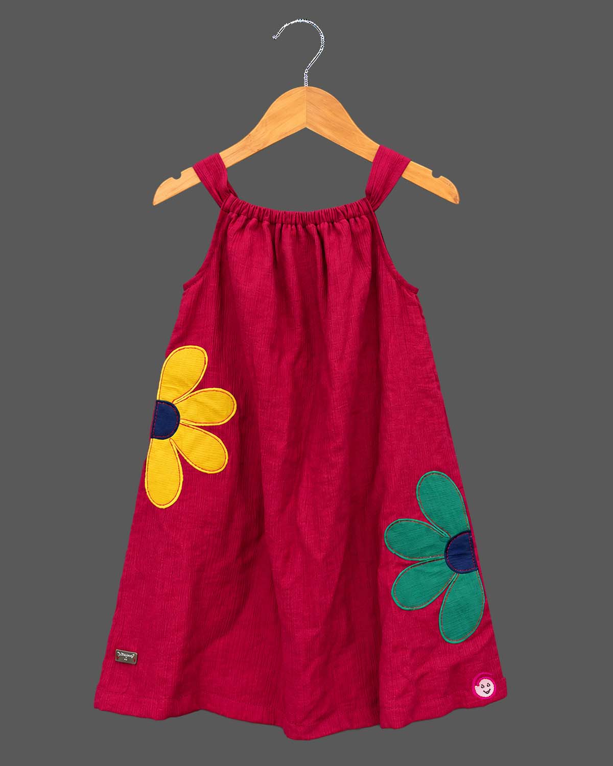 Baby girl lehenga style sleeveless dress with large floral appliques, soft textured weave, and flared silhouette.