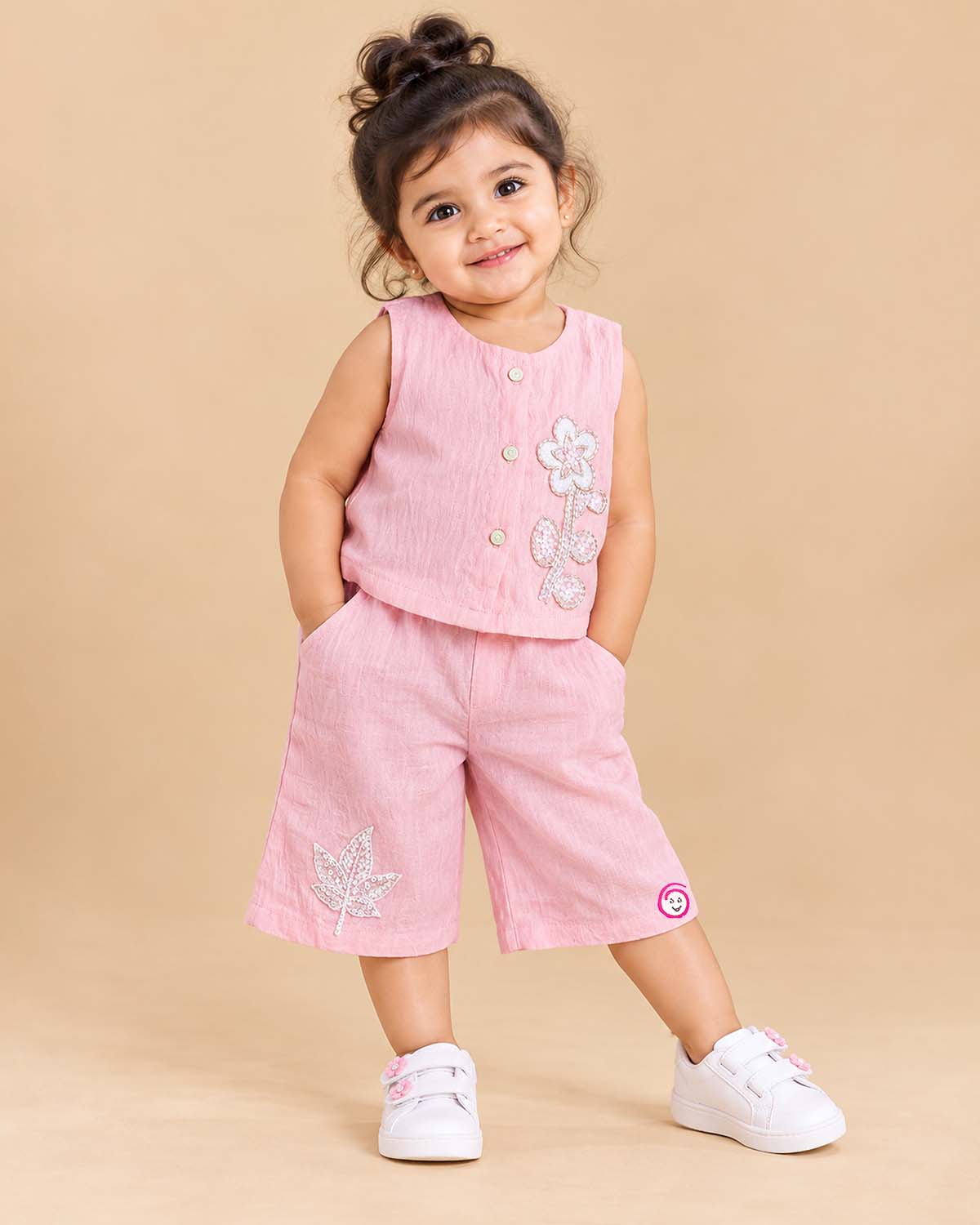 Sleeveless button-down top with floral applique and trousers set as a baby party wear dress.