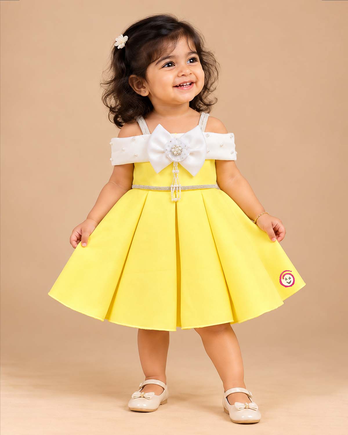 Scuba frock for baby girl featuring structured box pleats and pearl-embellished bow bodice.